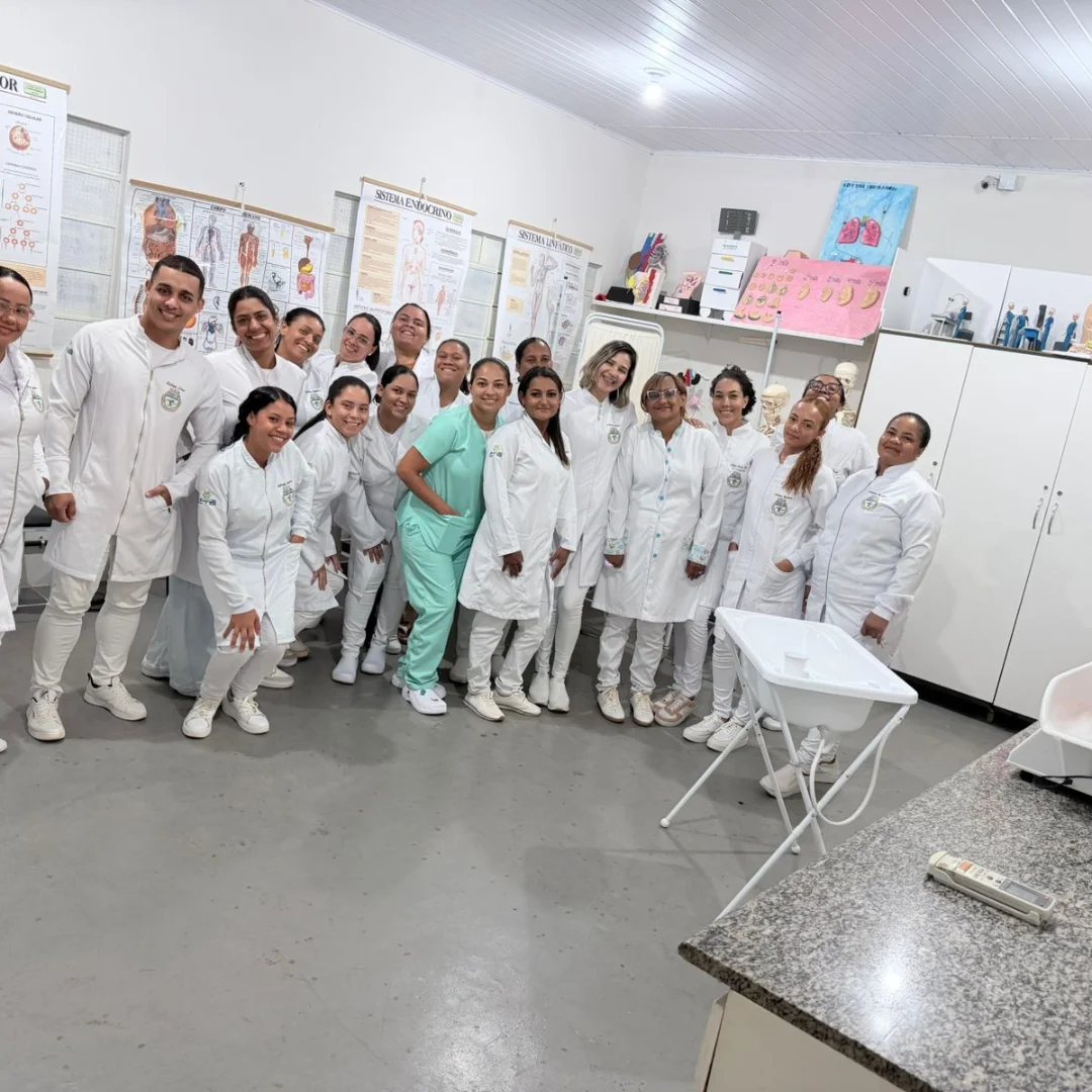 Turma do Colégio CTS de jaleco branco no laboratório de práticas de enfermagem
